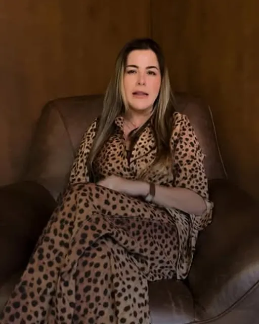 Post do Instagram: Michele Anadão sentada numa poltrona de couro, de vestido de oncinha